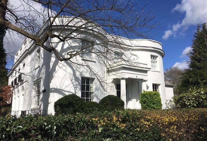 The entrance has an impressive porch framed by two fluted Doric columns.