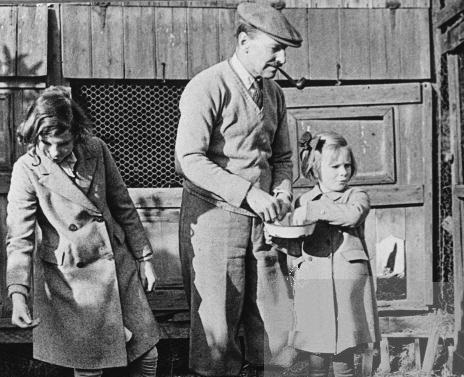 Feeding the chickens with his daughters, Alison and Felicity, at their home in Stanmore